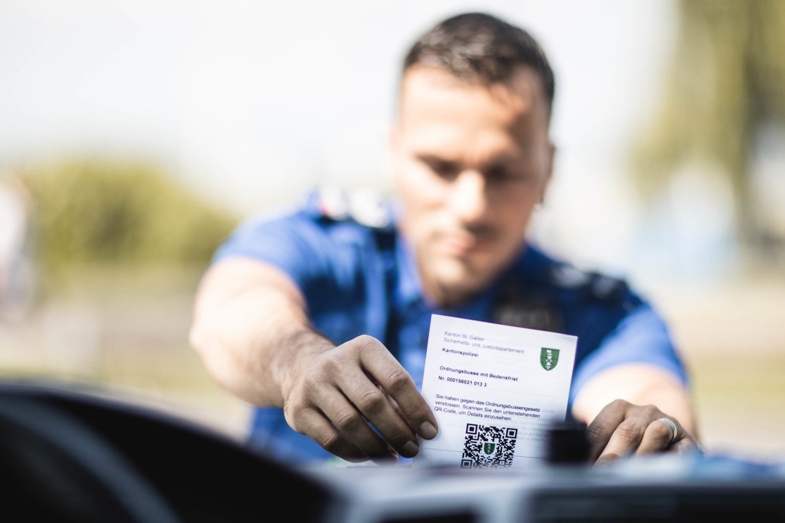 Symbolbild: Polizist verteilt Busse